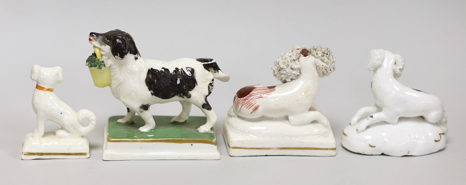 Four small Staffordshire models of spaniels; one seated on rectangular base, two lying recumbently, and the other standing on rectangular base, c.1830-50, (4), tallest 6cms high, Provenance Dennis G.Rice collection